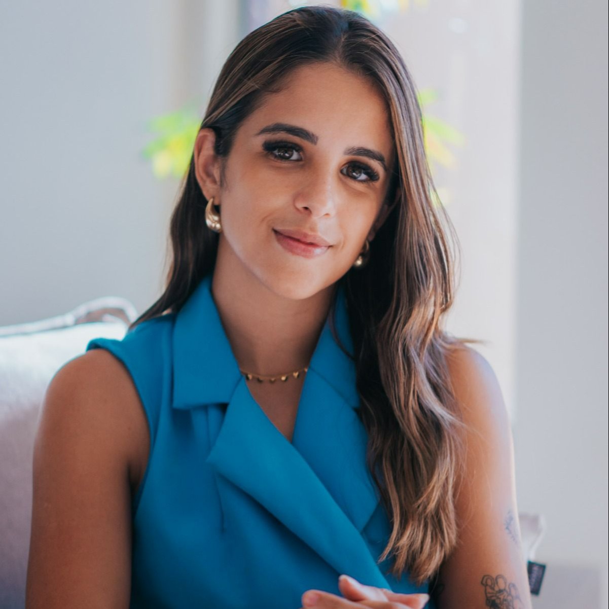 Gabriela Rocha, psicóloga, sentada em um ambiente iluminado